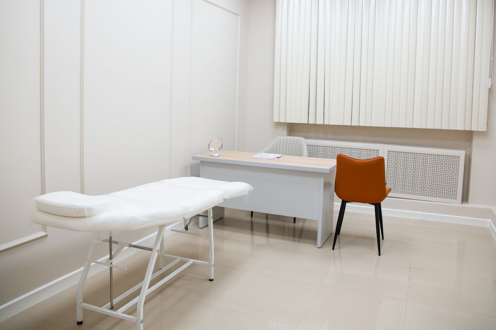 Cabinet m&eacute;dical moderne avec bureau, table d'examen et fauteuils