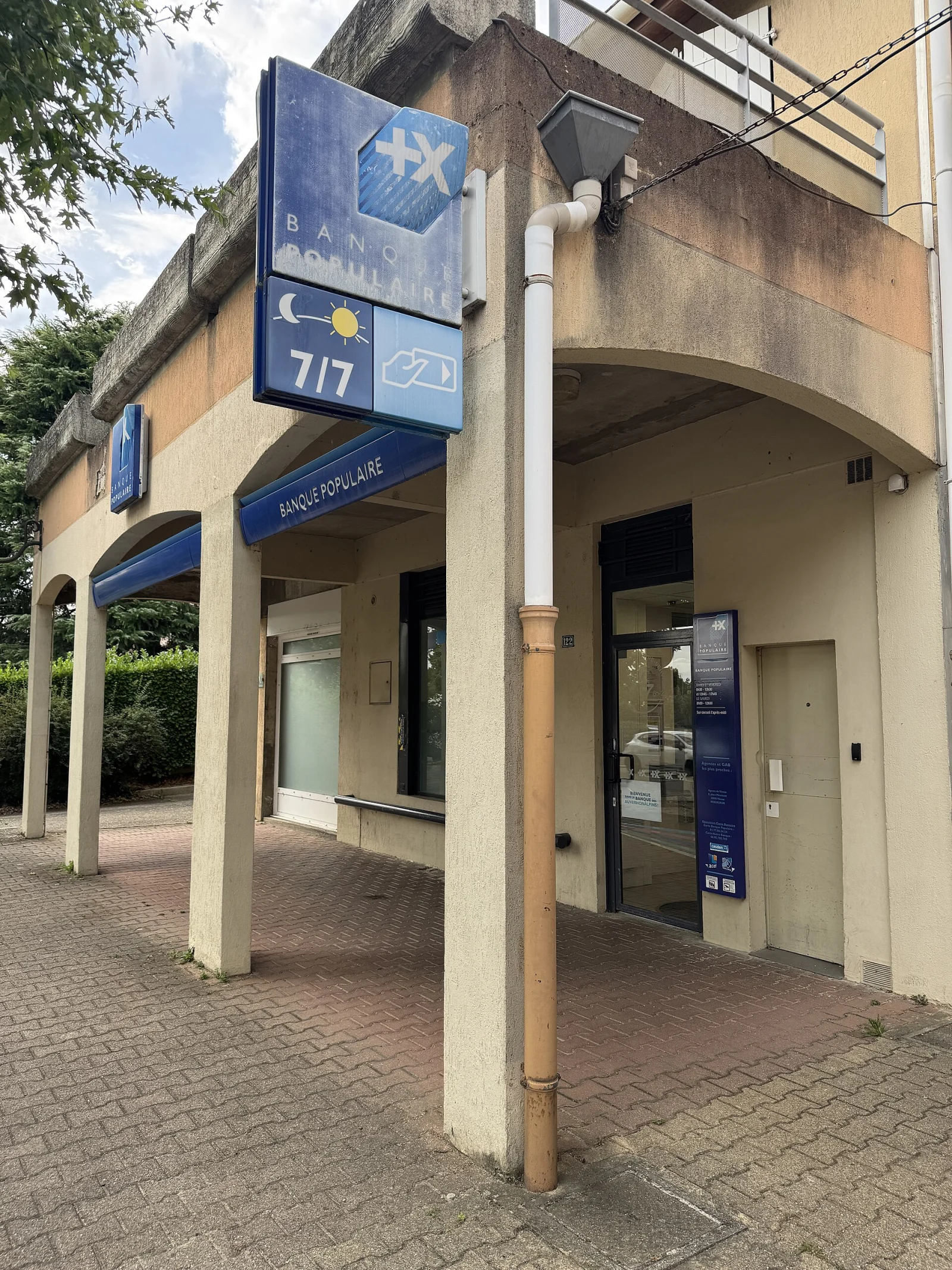 Fa&ccedil;ade et enseigne bleue d&rsquo;une agence Banque Populaire sous une galerie ext&eacute;rieure.