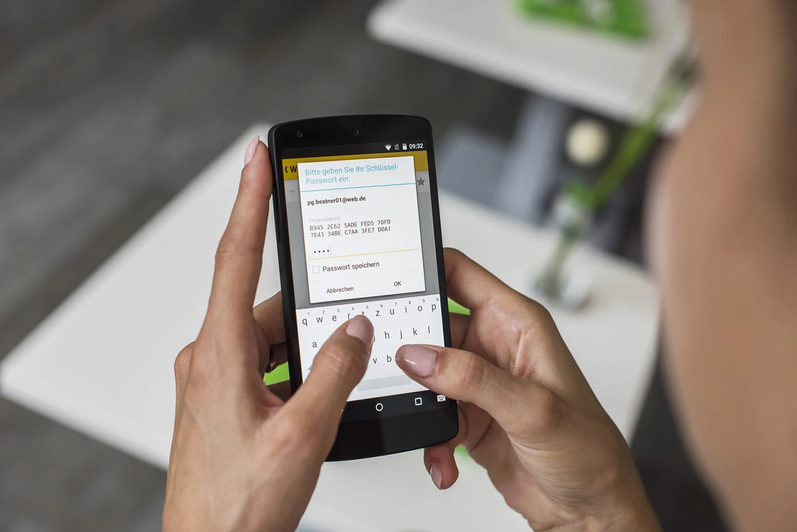 Vue par-dessus l&rsquo;&eacute;paule d&rsquo;une personne saisissant un mot de passe sur un smartphone.