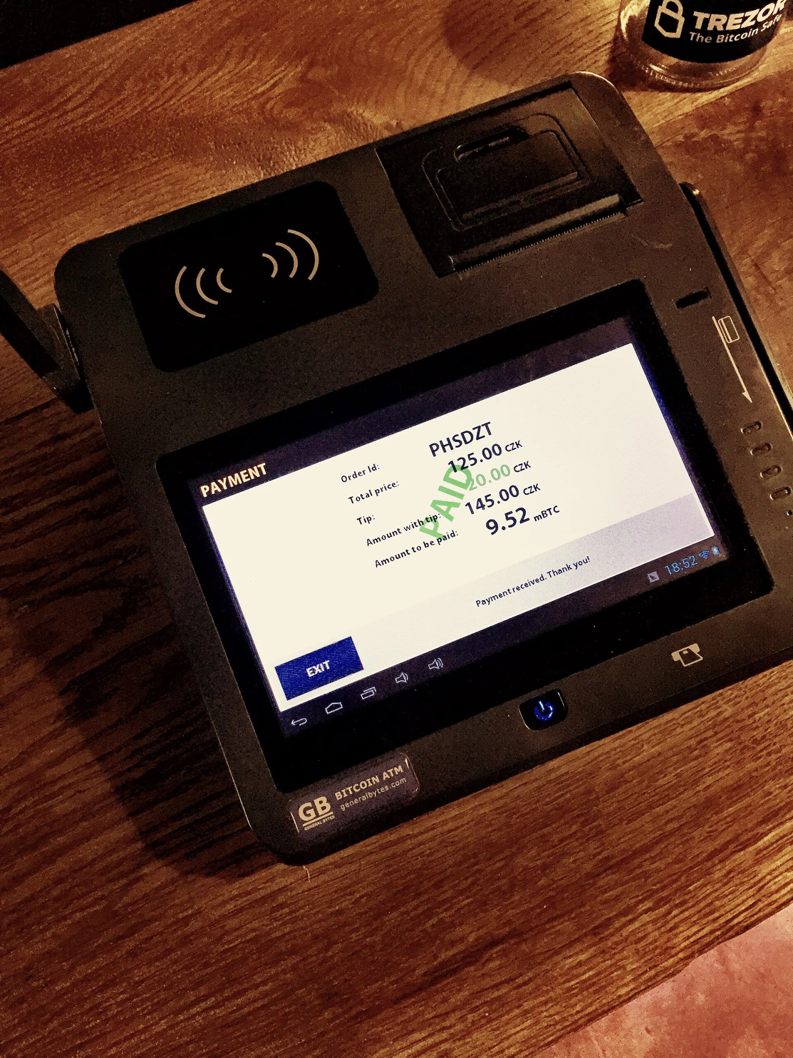Terminal de paiement Bitcoin dont l&rsquo;&eacute;cran affiche &laquo; PAID &raquo;.